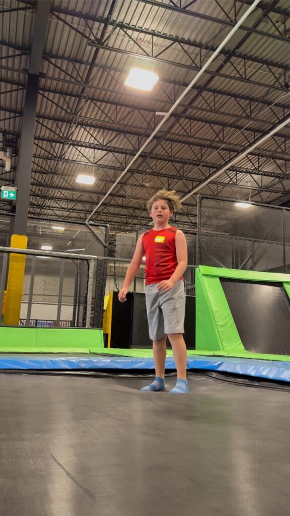 Boy jumps at a trampoline park.