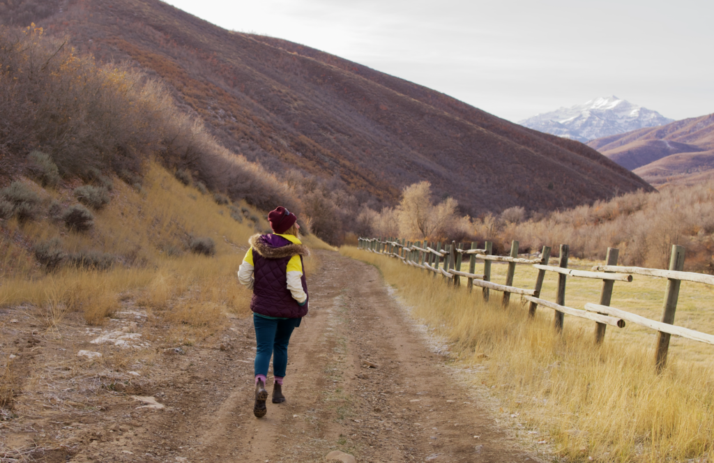 Ali runs down a frozen path amongst mountain terrain.